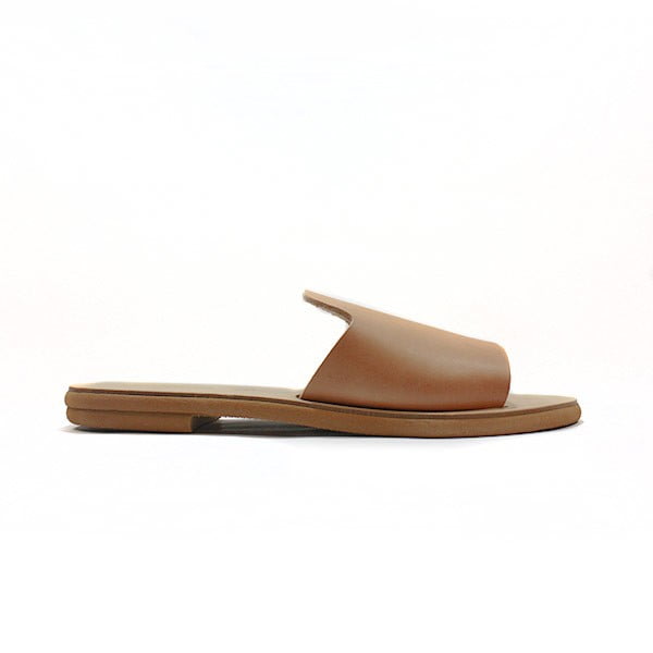 Tan Open toe Slide Sandal with a Flat Sole on a White Background Shown from the Side