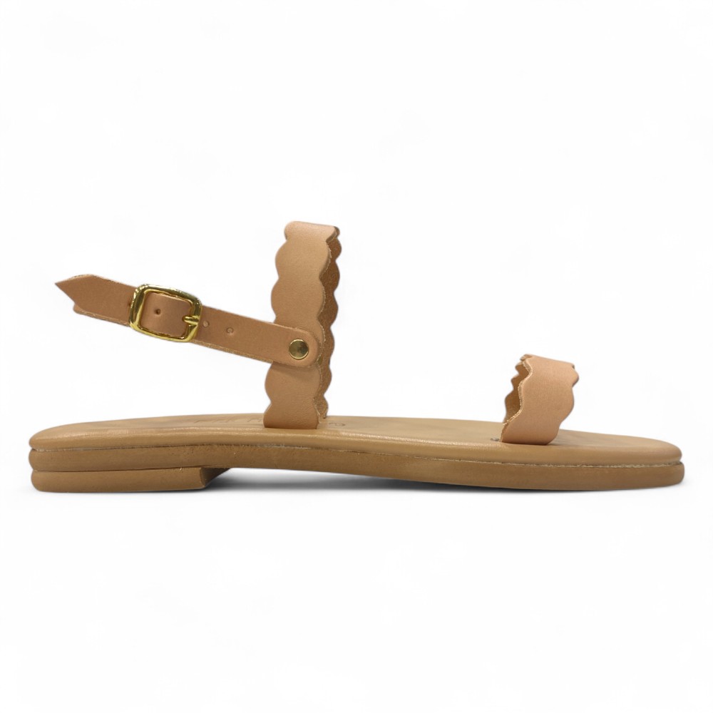 Tan Flat Sandal with Scalloped Straps and an Adjustable Ankle Buckle on a Light Background